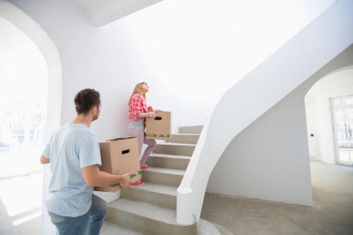 Team carrying furniture through a narrow staircase during a Barnet flat removal