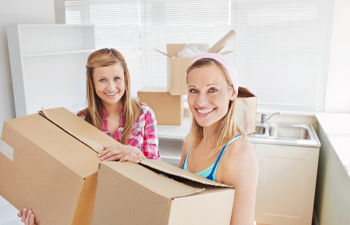 Workers using safe lifting techniques during a house move
